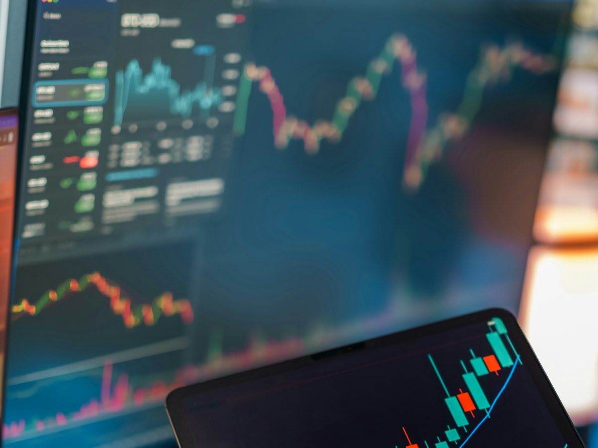 Financial trading charts across multiple screens